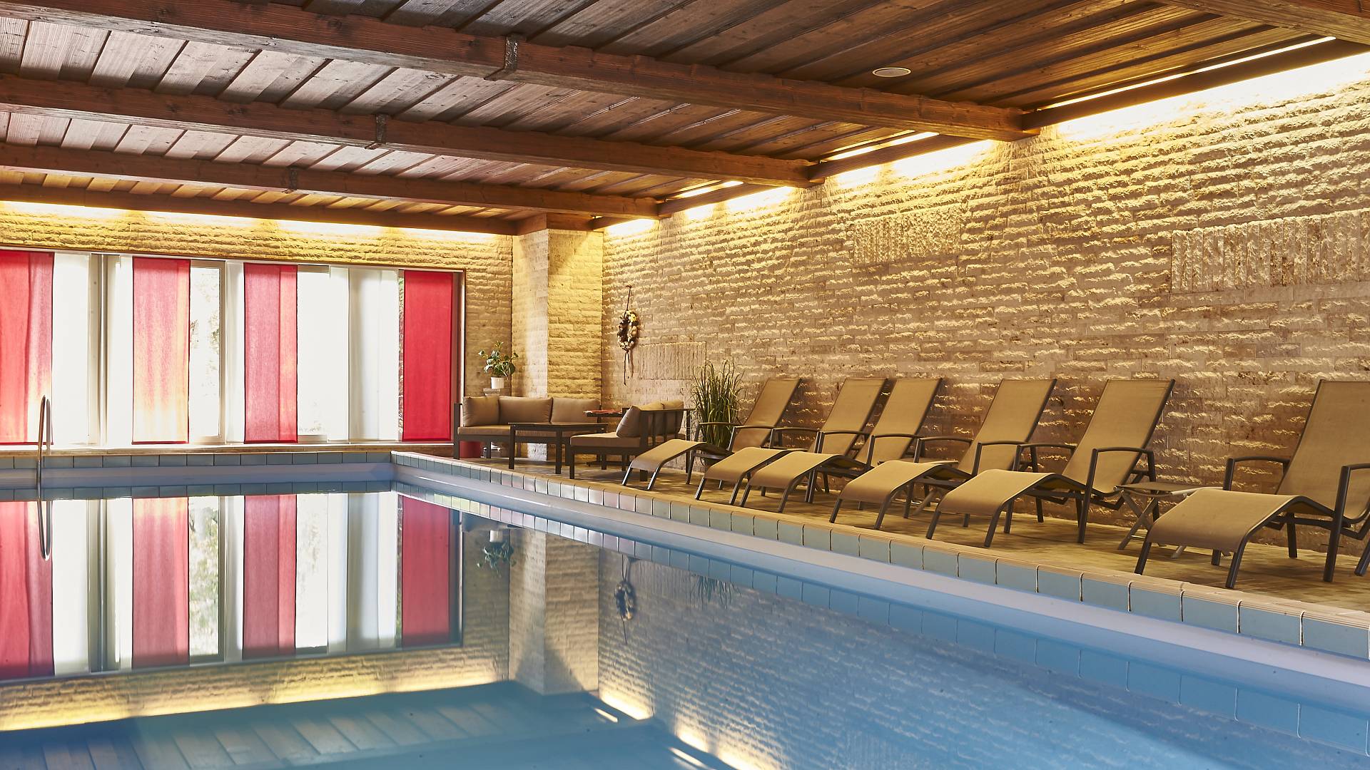 Indoor swimming pool with sunbeds at the poolside
