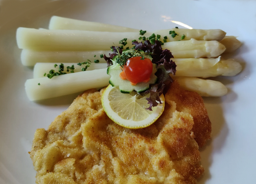 Portion of German asparagus with a small breaded schnitzel