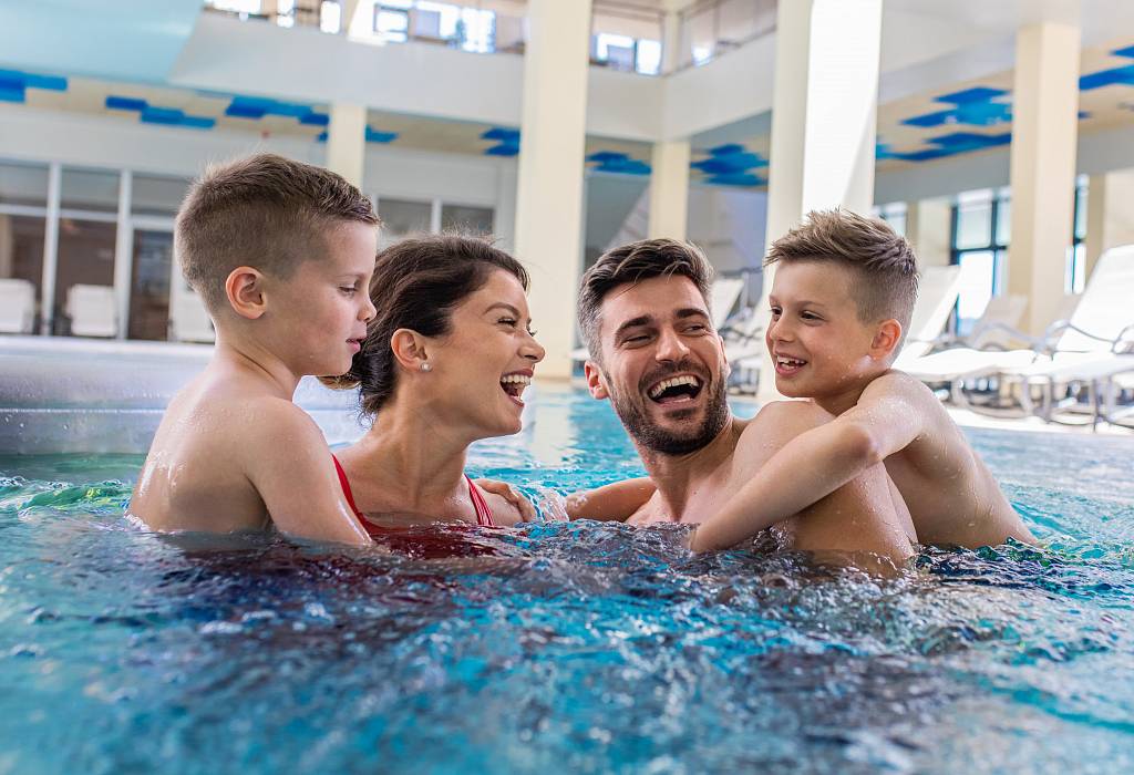 A photo of a family with two children in the water on an air mattress