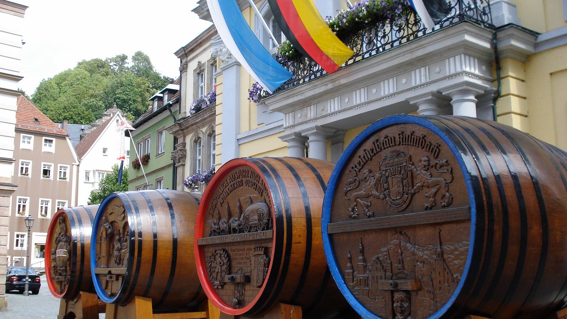 A shot in front of Kulmbach town hall with four large beer barrels [[source: 'Source: City of Kulmbach']]