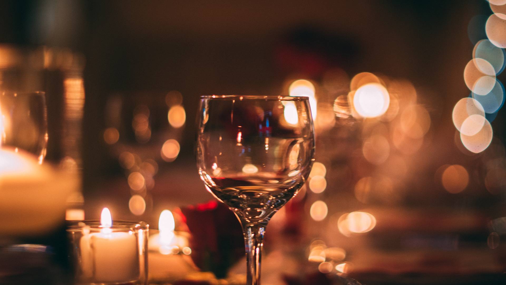 Kerzenschein und Weinglas bei Nacht
